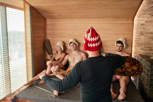 Группа друзей в традиционной русской бане с банщиком — стоковое фото