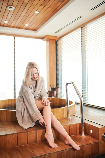 Mujer relajante cerca de baño de barril de madera con vidrio en el concepto de spa y sauna —  Fotos de Stock