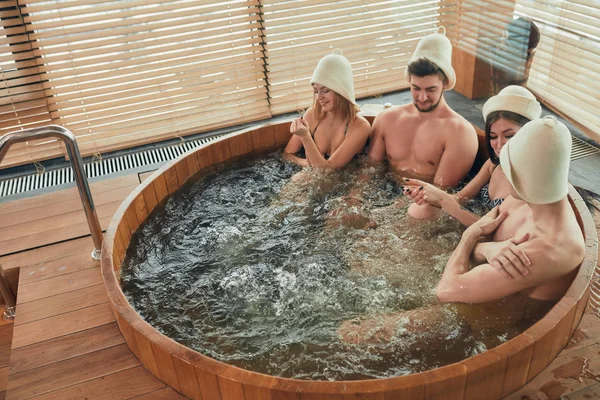 Groep Kaukasische divers vrienden genieten van jacuzzi in spa hotel — Stockfoto