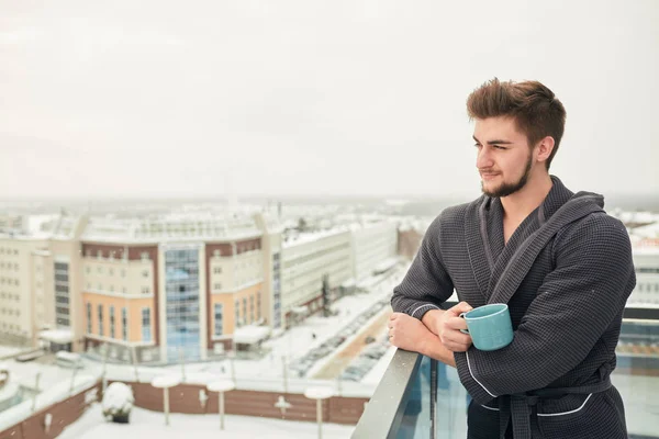 Bonito jovem relaxante no inverno terraço nevado depois de tomar banho de vapor — Fotografia de Stock