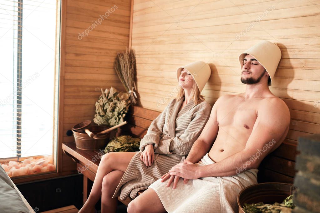 Beautiful couple relaxing in sauna and caring about health and skin