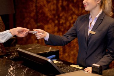Kolay hareket, kadın otel resepsiyonunda kredi kartıyla ödeme.
