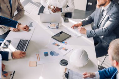 Çizelgeler ve grafikler ile toplantı iş adamları dizüstü bilgisayar kullanmak, kadar en iyi Görünümü Kapat.