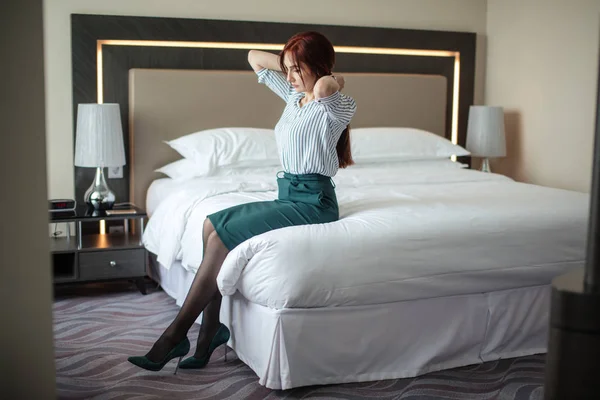 Senhora de negócios cansada depois de uma longa viagem descansando na cama no quarto de hotel . — Fotografia de Stock