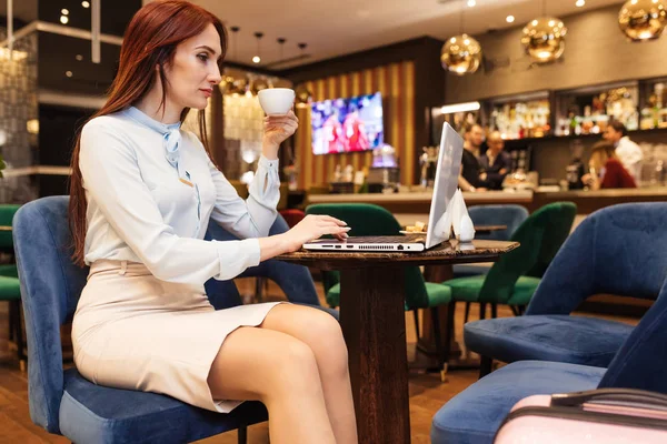 Geschäftsfrau arbeitet mit Laptop in Hotellobby und trinkt Kaffee — Stockfoto