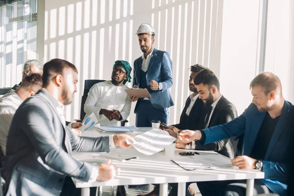 Dirigeants d'entreprise masculins multiraciaux discuter projet assis à la table de conférence — Photo