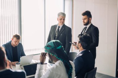 Bir grup iş adamı toplantı odasında beyin fırtınası yapıyor.