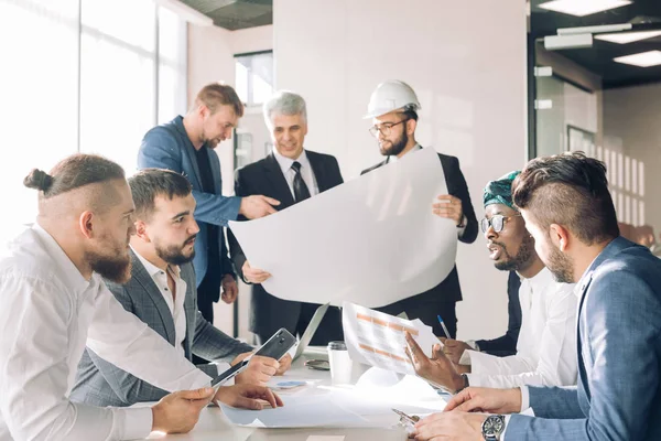 Grupo multirracial de construtores e arquitetos discutindo o projeto no escritório . — Fotografia de Stock