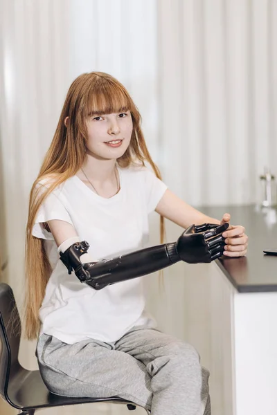 Ruhiges behindertes Mädchen in lässiger Kleidung mit künstlichem Gerät statt echtem Arm — Stockfoto