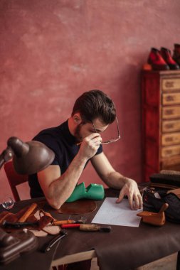 bir not yaparken gözlüklerini koyarak Ayakkabıcılık