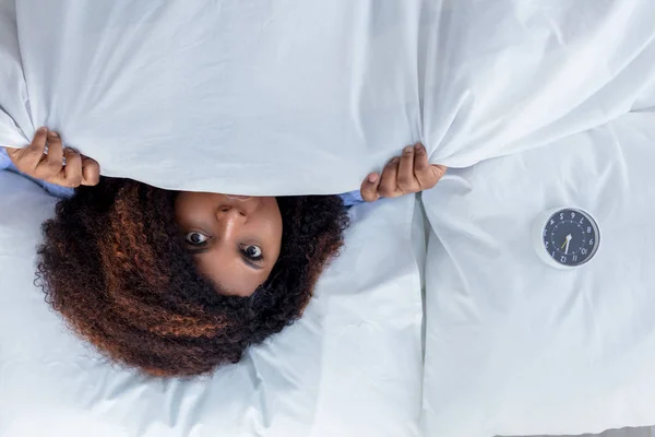 Mulher emocional escondido sob o cobertor branco — Fotografia de Stock