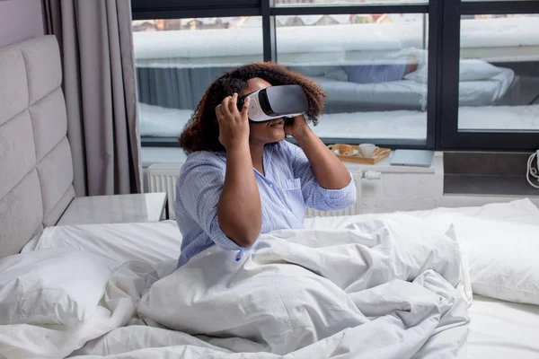 Menina agradável olhando embora dispositivo de realidade virtual em casa — Fotografia de Stock