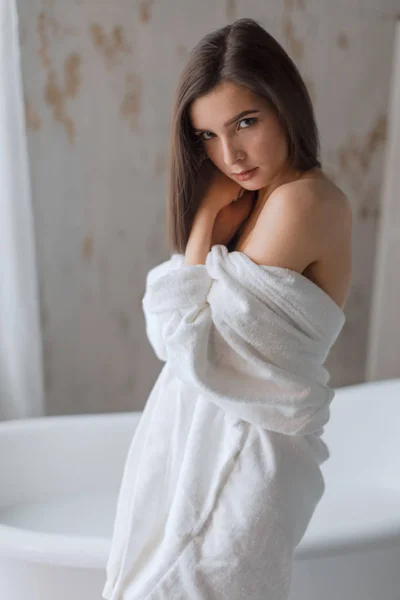 Linda jovem morena posando em um roupão de banho — Fotografia de Stock