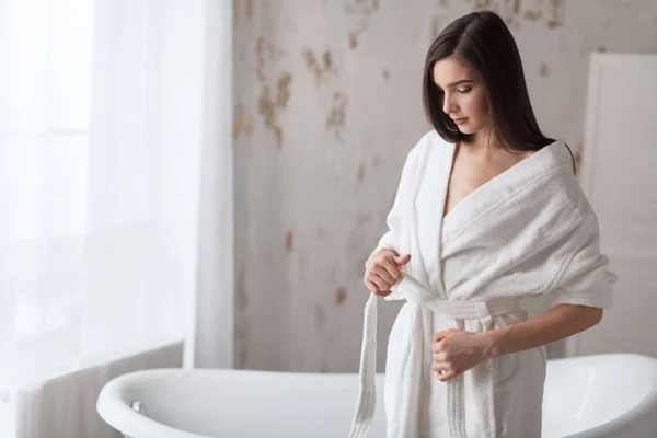 Mujer Spa. Mujer joven tierna con cabello castaño largo en bata de baño en el baño. — Foto de Stock