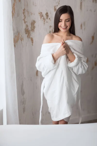 Mooie jonge dame in bad badjas gaan naar een bad te nemen in witte badkamer — Stockfoto