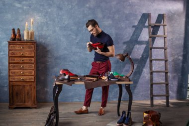 Genç kunduracı iş ayakkabı ile dikkatli bir şekilde