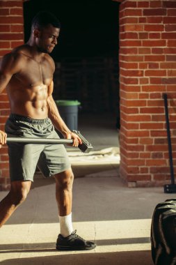 Kaslı adam tekerlek lastik çekiç kızak ile isabet