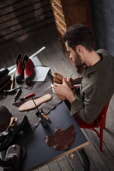 Sapateiro está escolhendo o tecido para sapatos — Fotografia de Stock