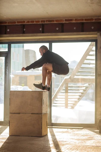 Caucásico atlético hombre realizando plyo box salto ejercicio durante crossfit entrenamiento — Foto de Stock