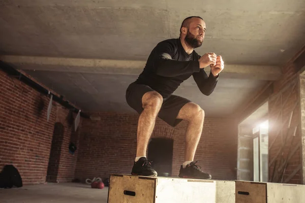 Kaukasischer athletischer Mann führt beim Crossfit-Training Plyo-Box-Jump-Übungen durch — Stockfoto