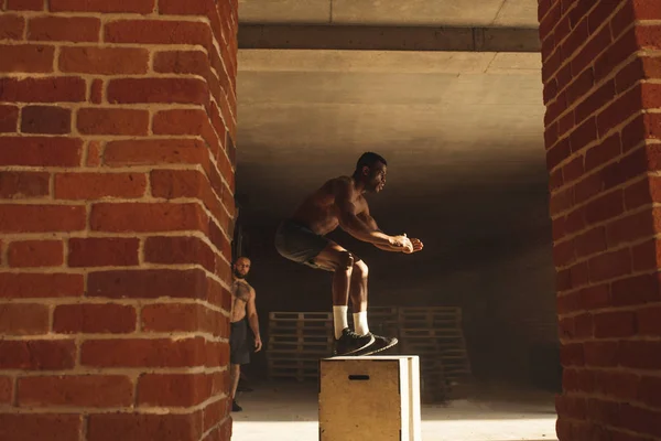 Passa afrikanska americanman box hoppa på en ruta på ett gym. — Stockfoto