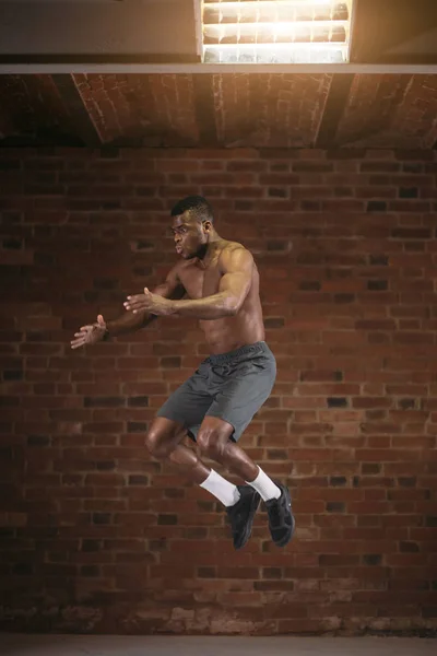 Afrikaanse man springen hoog in de lucht tijdens crossfit workout. Lifestyle Sport Power — Stockfoto