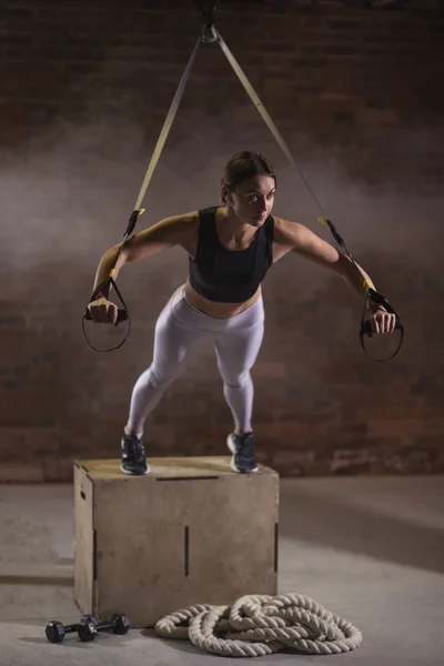 Fitness mulher treino em correias TRX no ginásio. Estilo Crossfit. Formação TRX . — Fotografia de Stock