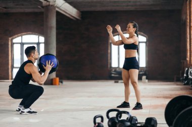 Sportif erkek ve kadın fitness topu birbirlerine spor Merkezi'nde atma