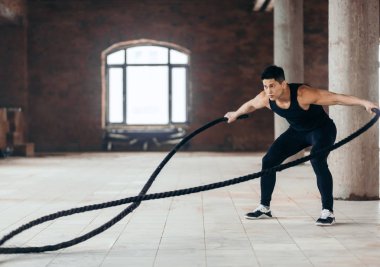awesome athlete develops muscles and cardio with battling rope clipart