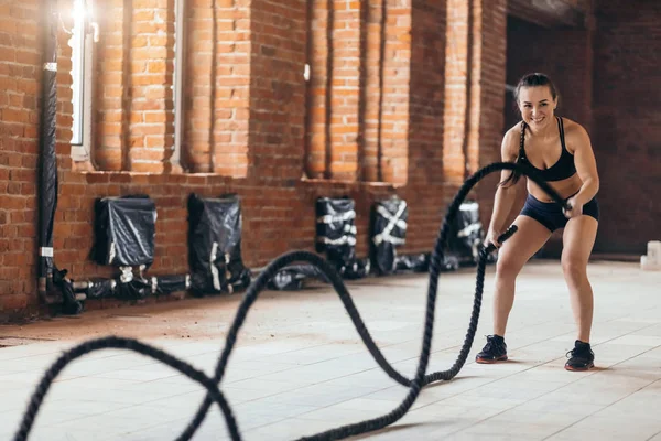 Awesome female athlete develops muscles and cardio with battling rope — Stock Photo, Image