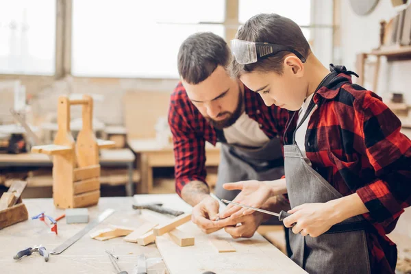 Padre e hijo pequeño en taller de madera usando destornillador. — Foto de Stock