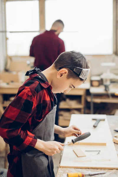 Padre e hijo pequeño en taller de madera usando destornillador. — Foto de Stock