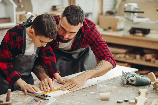 Men with ruler and pencil measuring wooden plank for work — Stock Photo, Image