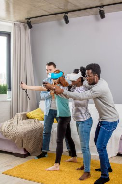 Çok kültürlü bir grup arkadaşıyla birlikte sanal gerçeklik gözlükle oyun oynamak.