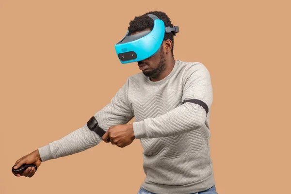 Black man wearing 3d vr glasses, playing videogame, holding joystick in hands