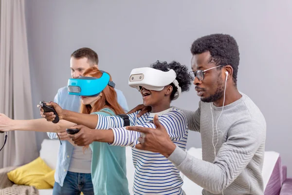 Groupe multiculturel d'amis jouant à des jeux en utilisant des lunettes de réalité virtuelle . — Photo