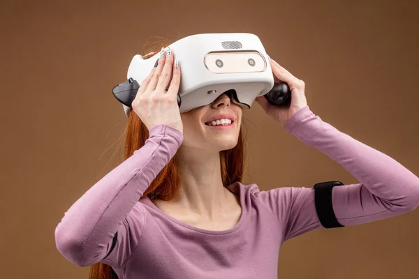 Χαρούμενος νεαρός Κοκκινομάλλης γυναίκα χρησιμοποιώντας μια κάσκα εικονικής πραγματικότητας — Φωτογραφία Αρχείου