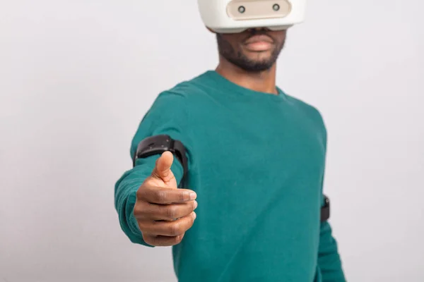 Африканський чоловік носить окуляри віртуальної реальності, тримає ігрові пристрої, ізольовані — стокове фото
