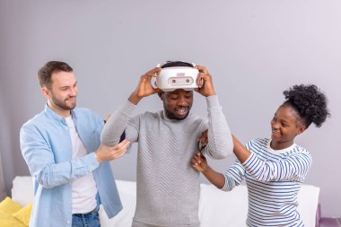 Çok kültürlü arkadaşlar Afrika adam için manade vr kulaklık ile fist saat için yardım