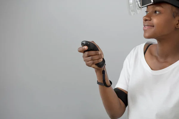 Young mixed race woman wearing virtual reality VR headset on white background.
