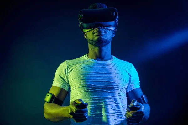 Uomo africano in bianco, indossando VR Headset su sfondo verde blu doppio colore . — Foto Stock
