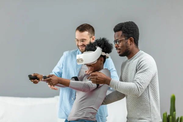 Deux hommes aident une femme africaine à essayer des lunettes de réalité virtuelle pour la première fois — Photo