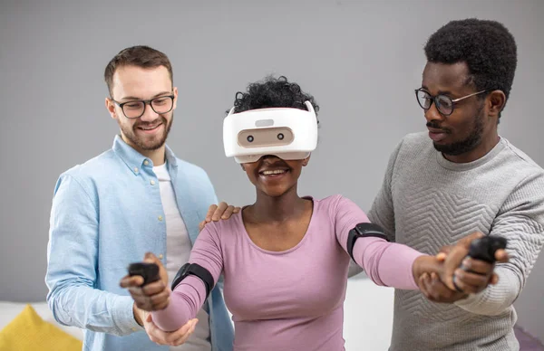 Dva chlapi pomoci Afričanka snaží na virtuální realita brýle pro první čas — Stock fotografie