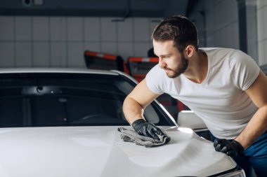 Genç sakallı adam araba boyama sonra silinerek