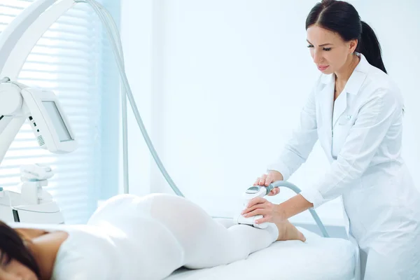 Kobieta klient kliniki kosmetycznej coraz masaż LPG na nogi do podnoszenia ciała — Zdjęcie stockowe