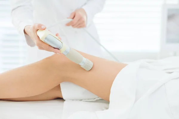 Cliente feminino da clínica de beleza recebendo massagem de GLP nas pernas para o corpo de elevação — Fotografia de Stock