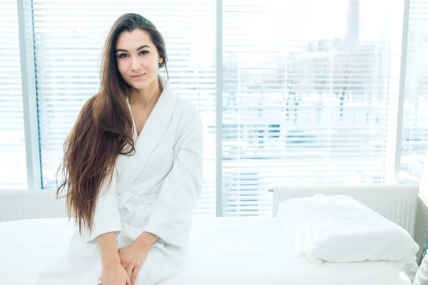 Ung brunett kvinna i vit badrock väntar på LPG massage session — Stockfoto
