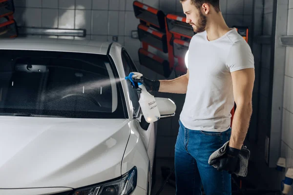 Junger Mann streut Waschseife auf die Windschutzscheibe — Stockfoto