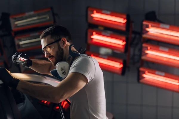 Impresionante lindo hombre examinando un nuevo coche — Foto de Stock