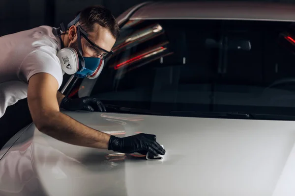 Cara trabalhador atraente limpando a poeira do carro — Fotografia de Stock